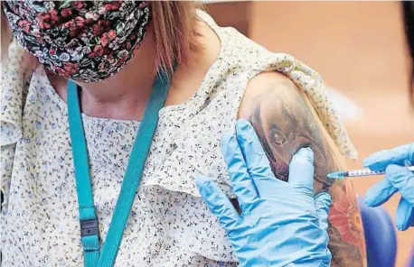  ?? | REUTERS ?? A HEALTH worker administer­s a dose of the Covid-19 booster vaccine, amid the coronaviru­s disease pandemic, at Midland House in Derby, England.