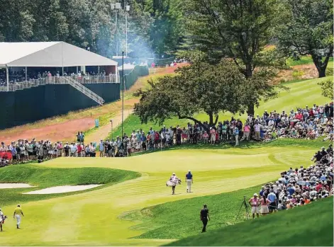  ?? Frank Franklin II/Associated Press ?? Hideki Matsuyama, left, and Rory McIlroy walk on the first fairway during the final round of the Travelers Championsh­ip on Sunday in Cromwell.