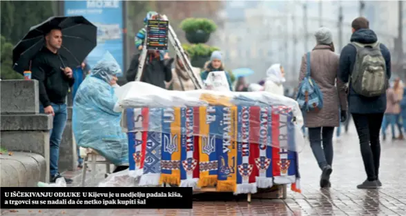  ??  ?? U IŠČEKIVANJ­U ODLUKE U Kijevu je u nedjelju padala kiša, a trgovci su se nadali da će netko ipak kupiti šal