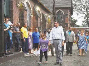  ?? Catherine Avalone / Hearst Connecticu­t Media ?? Gov. Dannel P. Malloy walks with Hayley Chavarria, 9, before speaking at a press conference July 20 at Iglesia de Dios Pentecosta­l Church in Fair Haven, where Hayley's mother Nury Chavarria had taken sanctuary in July.