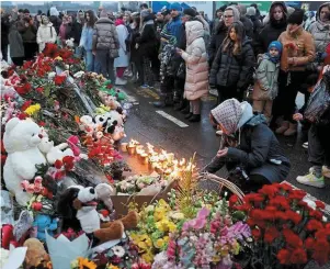  ?? | PHOTO : MAXIM SHEMETOV, REUTERS ?? Des Russes ont déposé des fleurs hier près du site de l’attaque terroriste qui a eu lieu la veille contre le Crocus City Hall près de Moscou.
