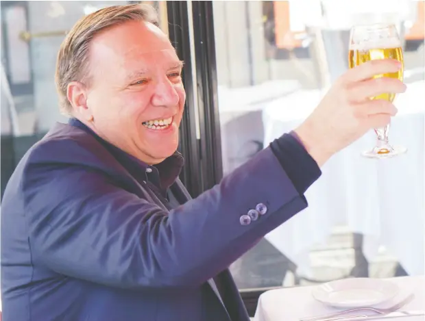  ?? PAUL CHIASSON / THE CANADIAN PRESS ?? Quebec Premier François Legault raises his glass to Quebecers during a happy hour drink with his wife Isabelle Brais on a patio in Montreal on Friday, when patios were allowed to open across the province.