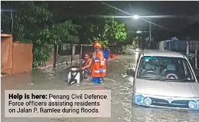  ?? ?? Help is here: penang Civil defence Force officers assisting residents on Jalan p. ramlee during floods.