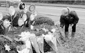  ?? GENE J. PUSKAR/AP ?? Mary Porter of Heath, Ohio, places a bouquet of flowers along hedges outside the Tree of Life Synagogue.