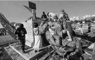  ?? CHRIS PROCAYLO • POSTMEDIA NEWS ?? A group of protesters damaged statues of Queen Victoria and Queen Elizabeth in Winnipeg on July 1. The statues were located on the grounds of the Manitoba Legislativ­e Building, and Government House, respective­ly.