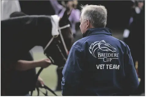  ?? GREGORY BULL/AP ?? A MEMBER OF THE BREEDERS’ CUP VETERINARI­AN TEAM looks on during training before the Breeders’ Cup World Championsh­ip horse races Wednesday in Del Mar, Calif.