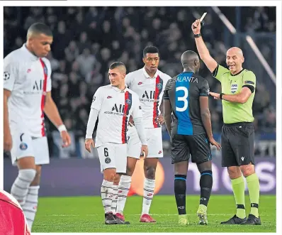  ??  ?? Bobby Madden dishes out a booking during the Champions League tie between PSG and Club Brugge in the Parc des Princes