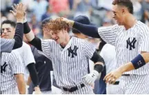  ?? ASSOCIATED PRESS FILE PHOTO ?? The New York Yankees’ Clint Frazier, center, is congratula­ted by teammates, including Aaron Judge, right, after hitting a three-run walkoff home run during the ninth inning of a July 8 interleagu­e game against the Milwaukee Brewers at Yankee Stadium.