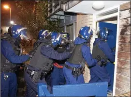  ??  ?? Swoop: Police storm a house in South London at dawn yesterday