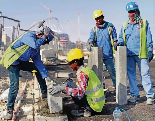  ?? FOTO: ANDREAS GEBERT/DPA ?? Gastarbeit­er aus Indien und Bangladesc­h vor dem Khalifa-Stadion in Doha. Der gesetzlich­e Mindestloh­n beträgt seit zwei Jahren 1000 Riyad, umgerechne­t rund 250 Euro.