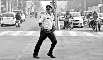  ??  ?? Photo shows Singh directs traffic while ‘moonwalkin­g’ at an intersecti­on in Indore. — AFP photo