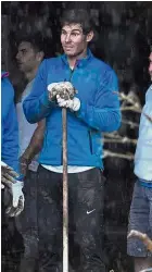  ?? — AP ?? Dressed for work: Rafael Nadal works with residents to clear the mud from their houses after flooding in Sant Llorenc, 60km east of Majorca’s capital, Palma, Spain, on Wednesday.