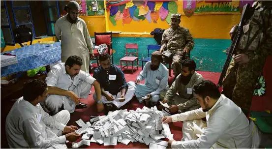  ?? Farooq Naeem/AFP ?? Contagem manual de votos na localidade paquistane­sa de Rawalpindi; resultado final deve ser conhecido hoje