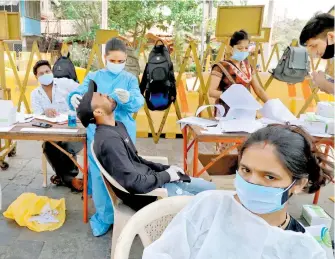  ??  ?? Trabajador­es de la salud realizan pruebas masivas en Bombay /REUTERS