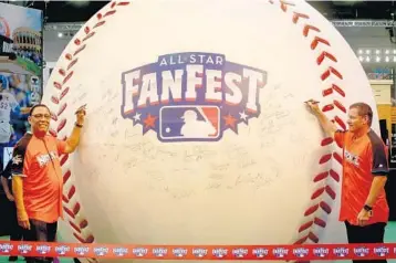  ?? MIKE STOCKER/STAFF PHOTOGRAPH­ER ?? Hall of Famer, former Marlins manager and current executive Tony Perez, left, and former Marlins player Jeff Conine add their signatures to the “World’s Largest Baseball” to kick off FanFest on Friday.