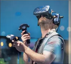  ?? By Ethan Millman ?? AN E3 VISITOR plays a VR game. Virtual reality developers aim to bring the player as close to the real feeling as possible.