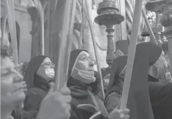  ?? MAYAALLERU­ZZO/AP ?? Palm Sunday: Nuns hold palm fronds during Palm Sunday Mass in the Church of the Holy Sepulchre in the Old City of Jerusalem. After a year of coronaviru­s restrictio­ns, Holy Week services are resuming in many parts of the world.