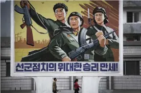  ?? Photograph: Wong Maye-E/AP ?? North Koreans pass a mural in Wonsan celebratin­g Songun,the ‘military-first’ policy that allocates resources to the armed forces. Former prisoners report deaths from malnutriti­on after being fed only handfuls of maize each day.