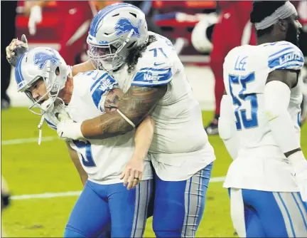  ?? RICK SCUTERI — THE ASSOCIATED PRESS ?? Detroit Lions’ Danny Shelton, center, embraces teammate Matt Prater, left, after Prater kicked the game-winning field goal as time expired against the Arizona Cardinals on Sunday. The Lions edged the Cardinals, 26-23, to end an 11-game losing streak going back to last season.