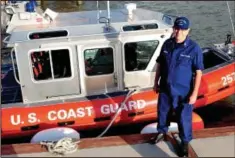  ?? MORNING JOURNAL/SAM GREENE ?? US Coast Guard Auxiliary Commander Russ Cromwell poses with a boat yesterday at the Coast Guard dock in Lorain.