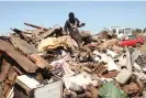  ?? Photograph: Nyasha Chingono ?? Colin Mapuranga sits on a pile of metal in a scrap yard near Hopley, a settlement outside Harare.