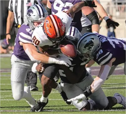  ?? CHARLIE RIEDEL/AP ?? Oklahoma State’s Brennan Presley (80) fumbles as he is tackled by Austin Moore (41) and Brendan Mott (38).