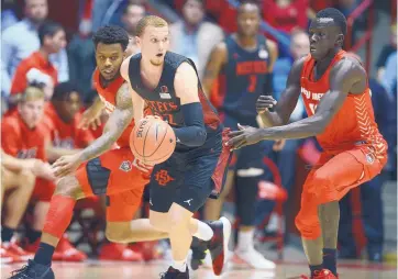  ?? ADOLPHE PIERRE-LOUIS/JOURNAL ?? San Diego State’s Malachi Flynn dribbles against defenders Vante Hendrix, left, and Makuach Maluach during the Aztecs’ win in Albuquerqu­e on Jan. 29. Flynn is one of the top guards in the nation.