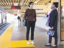  ?? Jessica Christian / The Chronicle ?? Two friends wait for a train at MacArthur Station. BART is reducing service in the face of drasticall­y reduced demand.