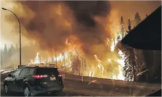  ?? JEROME GAROT ?? Flames encroached on Highway 63, the one road leading out of Fort McMurray.