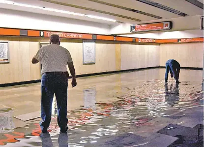  ?? JUAN CARLOS BAUTISTA ?? Empleados del Metro realizan labores para desalojar el agua de la estación Martín Carrera.