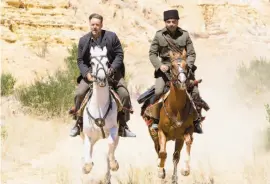  ?? Mark Rogers / Warner Bros. Pictures ?? Russell Crowe ( left) as Joshua Connor, a grieving father, and Yilmaz Erdogan as Maj. Hasan, who assists Connor in locating the remains of his lost sons, in the drama “The Water Diviner.”