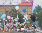  ?? Joe Raedle Getty Images ?? IN AURORA, Colo., a memorial grows for moviegoers killed during “The Dark Knight Rises” in 2012.