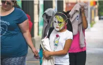  ?? GREGG VIGLIOTTI/NEW YORK TIMES ?? Children who were separated from their parents at the U.S. border cover their faces as they arrive at the Cayuga Centers, a nonprofit welfare agency, in the East Harlem neighborho­od of New York on Thursday. More than a dozen white vans lined up outside...