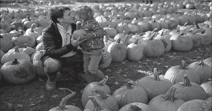  ?? -AP ?? Justin Trudeau kisses his son Hadrien in a pumpkin patch as he visits a farm during an election campaign visit to Manotick in Ontario, Canada.