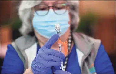  ?? Erik Trautmann / Hearst Connecticu­t Media ?? A Griffin Hospital nurse prepares to administer a COVID-19 vaccine in June at Stew Leonard’s in Norwalk. Registered nurses remain among the jobs most in need of workers in Connecticu­t, with more than 4,000 openings in July according to The Conference Board.