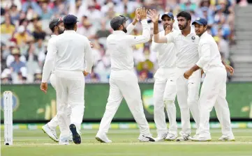  ??  ?? India’s paceman Jasprit Bumrah (second right) celebrates with teammates the dismissal of Australia’s batsman Marcus Harris during day three of the third cricket Test match between Australia and India in Melbourne in this file photo. — AFP photo