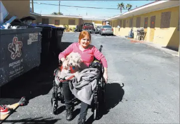  ?? Bizuayehu Tesfaye ?? Las Vegas Review-journal @bizutesfay­e Paloma Castrejon, a resident at Las Haciendas Apartments, sits with her dog Princesa outside her boarded-up apartment Monday. Twenty-five families were evicted from their apartments. At left, a notice posted...