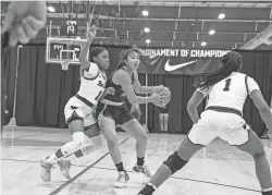  ?? MEGAN MENDOZA/THE REPUBLIC ?? Aila Kaibara (14) of Phoenix Country Day School, looks to pass the ball, guarded by Sloan Williams (2) and Janiyah Bone (1) of the Bob Jones Patriots during a game at the Nike Tournament of Champions at Legacy Sports Park on Dec. 18 in Mesa, AZ.