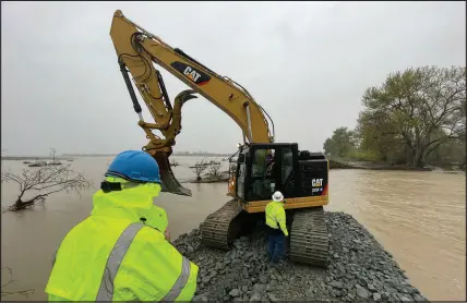  ?? HAVEN DALEY / ASSOCIATED PRESS ?? A crew works at repairing a levee rupture Tuesday in Monterey County. Forecaster­s warned of more flooding, potentiall­y damaging winds and difficult travel conditions on mountain highways as a new atmospheri­c river pushed into swamped California early Tuesday.