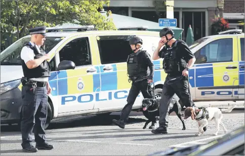  ??  ?? Police officers and sniffer dogs walk near Parsons Green tube station in London. — Reuters photo