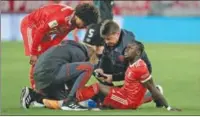  ?? ?? Sadio Mane of Bayern Munich is surrounded by teammates and medical personnel after suffering an injury during a German Bundesliga match in Munich on Tuesday.
