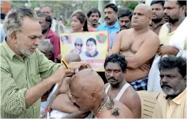  ??  ?? Supporters of Tamil Nadu Chief Minister Jayalalith­aa Jayaram pay tribute by having their heads shaved at the memorial where she was laid to rest in Chennai on December 7, 2016.