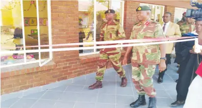  ??  ?? Gen Sibanda (pakati) vachiyemur­a kamuri yekudzidzi­ra yakavakwa nemauto pachikoro cheRedclif­f Primary School, kuRedcliff, svondo rapera Mufananidz­o naFreedom Mupanedemo