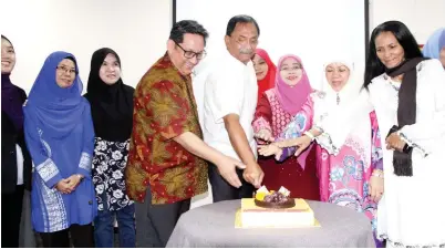  ??  ?? JAUJAN (lima kiri) diiringi Jasni (empat kiri) dan Asmiah (dua kanan) memotong kek majlis pelancaran buku Antologi Cerpen Bunang-Bunang.