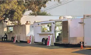  ?? MICHAEL LAUGHLIN/SOUTH FLORIDA SUN SENTINEL ?? A chef prepares dishes inside a Reef Kitchen food trailer, a type of a ghost kitchen, inside a parking lot across the street from the Broward County Courthouse in downtown Fort Lauderdale. The ghost kitchen operates as many as 11 virtual restaurant­s, and customers can order from them exclusivel­y through food-delivery apps.