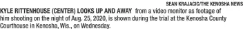  ?? SEAN KRAJACIC/THE KENOSHA NEWS ?? KYLE RITTENHOUS­E (CENTER) LOOKS UP AND AWAY from a video monitor as footage of him shooting on the night of Aug. 25, 2020, is shown during the trial at the Kenosha County Courthouse in Kenosha, Wis., on Wednesday.