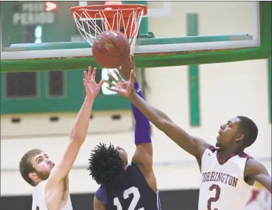  ?? H John Voorhees III / Hearst Connecticu­t Media ?? Amistad’s Cyprin Joseph (12) goes up to the basket between Torrington’s Kevin Dixon, left, and Ty Davis (2) in the CIAC Division III boys basketball semifinal game Wednesday at Wilby High School in Waterbury.