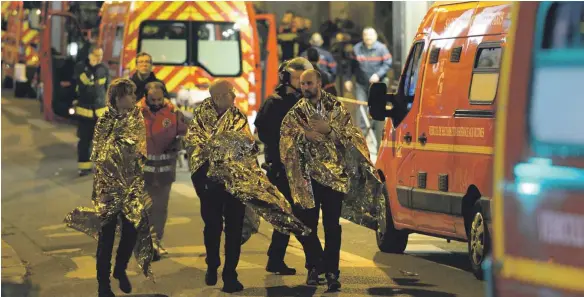  ?? FOTO: AFP ?? Großalarm für alle Rettungskr­äfte: Nach dem Anschlag auf die Konzerthal­le „Bataclan“in Paris werden Überlebend­e in Sicherheit gebracht.