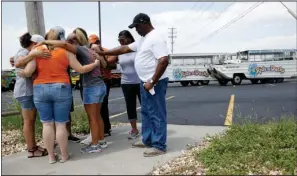  ?? The Associated Press ?? DUCK BOAT CAPSIZES: People pray outside Ride the Ducks, an amphibious tour operator involved in a boating accident Friday on Table Rock Lake in Branson, Mo.