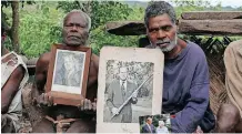  ?? | REUTERS ?? VILLAGE chief Jack Malia from Tanna island holds pictures of Britain’s Prince Philip in Younanen where the prince is worshipped, Vanuatu May 6, 2017.